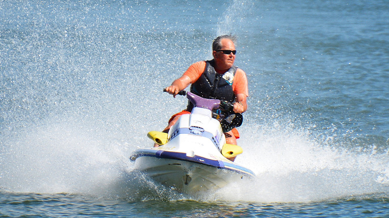 A senior man on a ski-doo on a lake on a sunny day in Colorado.
