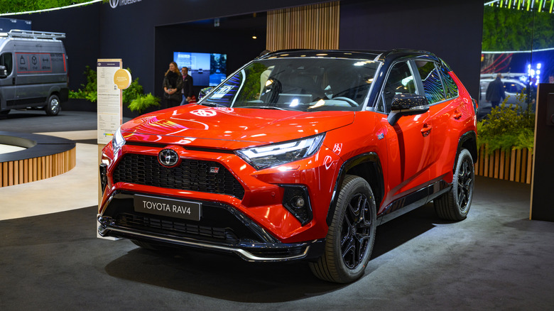 A red Toyota RAV4 GR Sport crossover hybrid on display at the AutoSalon.
