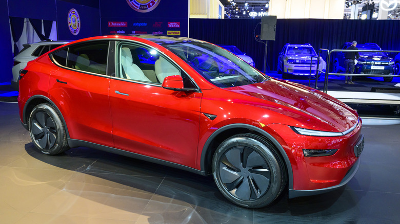 A red Tesla Model Y electric compact crossover SUV on display.