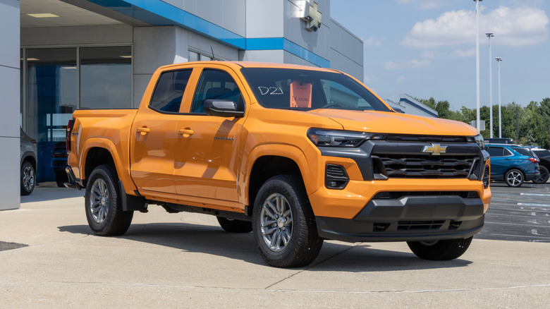 A new orange Chevrolet Colorado 4WD LT Crew Cab pickup at a dealership.