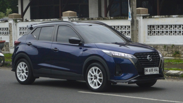 A blue hatchback 2022 Nissan Kicks E-Power is passing through the streets