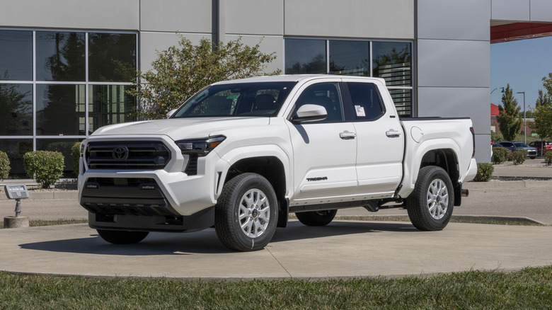 A white Toyota Tacoma SR5 4X4 Double Cab at a dealership.