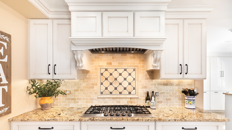 white kitchen cabinets featuring crown molding