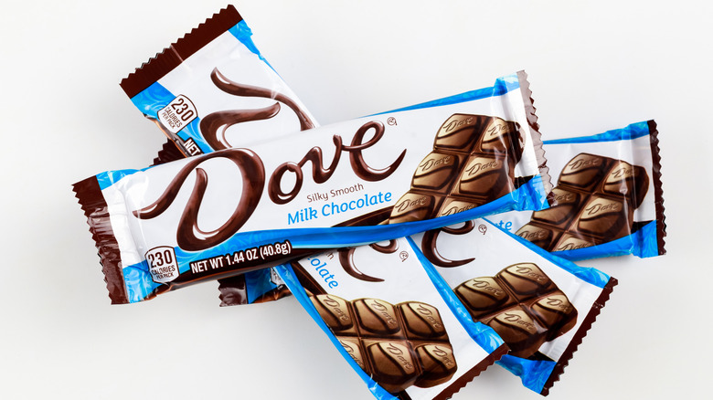 Pile of several candy bars with Dove written on front of white wrappers