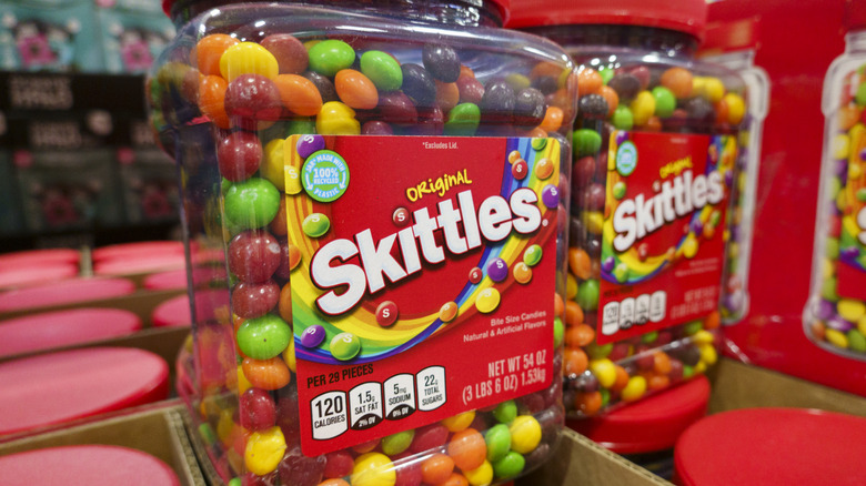 Image of two large containers of Skittles rainbow-colored candy