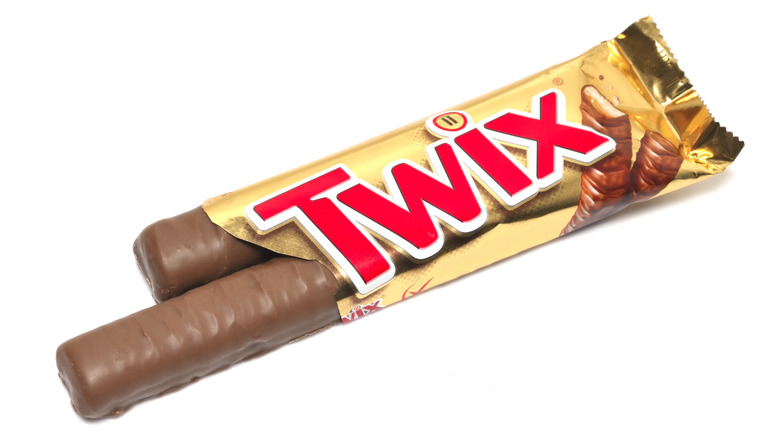 Opened Twix candy bar with two thin chocolate bars slid out of the package