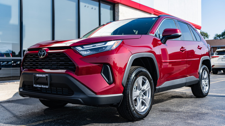 A red 2024 Toyota RAV4 crossover SUV on display.