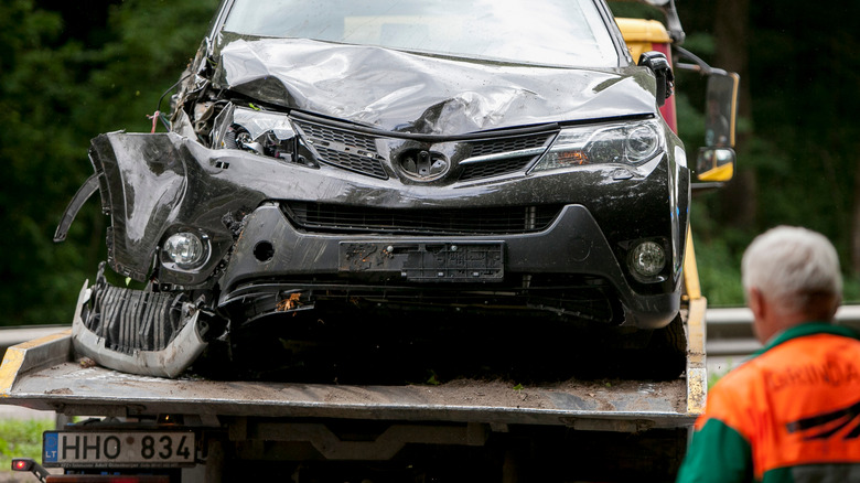 A crashed Toyota RAV4 on a tow truck.