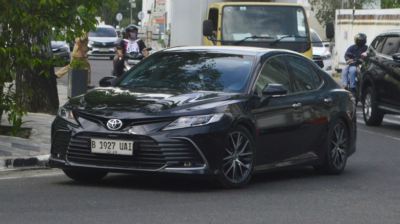 A black sedan 2022 Toyota Camry XV70 2.5V on the street.