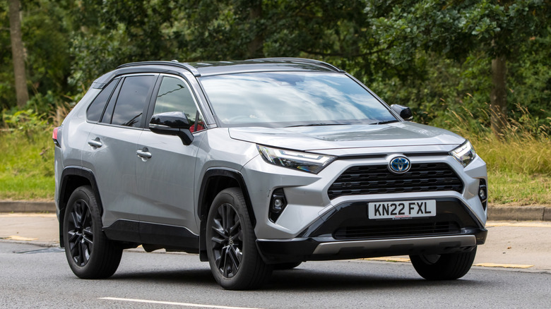 A 2022 silver Toyota RAV4 driving on an English road.