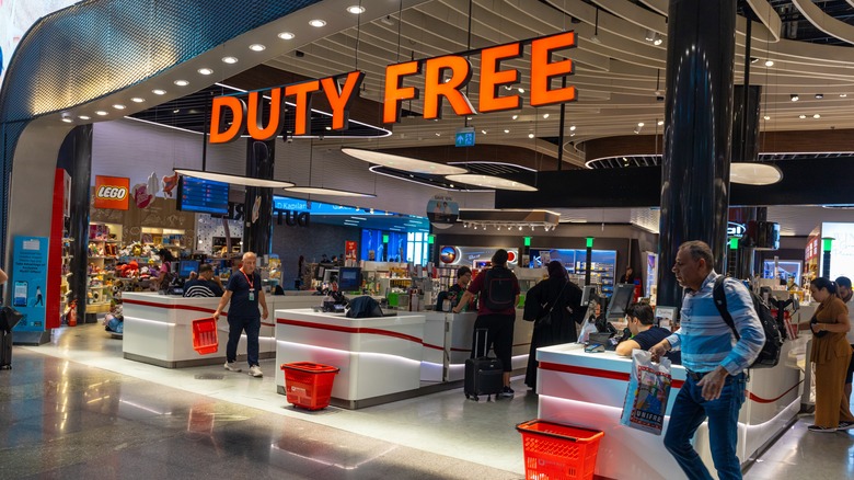 entrance to duty-free shop with man exiting as other customers stand in checkout lines