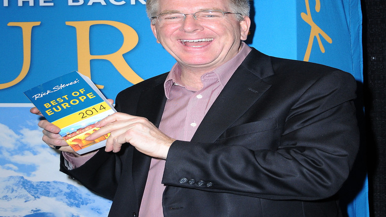 Rick Steves holding one of his travel guides