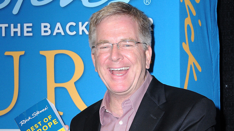 Rick Steves holding one of his travel guides
