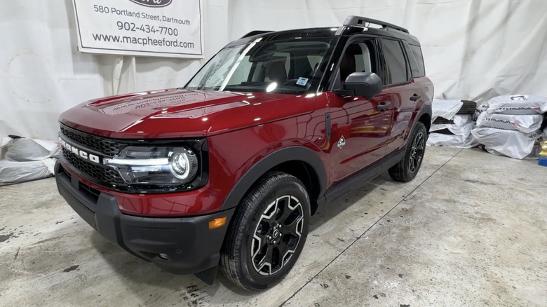 A red 2026 Ford Bronco Sport Outer Banks model on display at a dealship