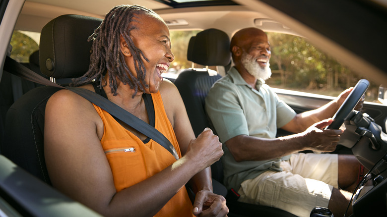 An older couple enjoying a laugh while driving