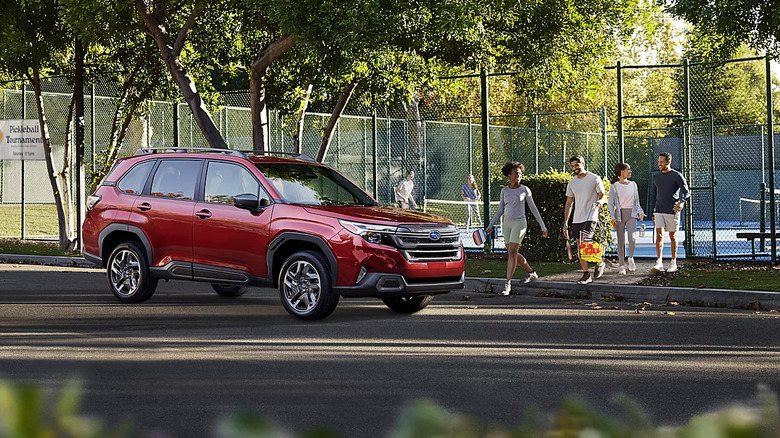 red Subaru Forester parked outside pickleball courts with three couples nearby