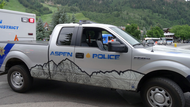 An Aspen Police SUV parked in front of rolling hills in Colorado.