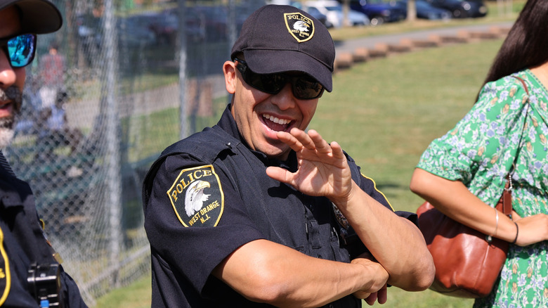 A smiling West Orange, New Jersey police officer waving at the camera