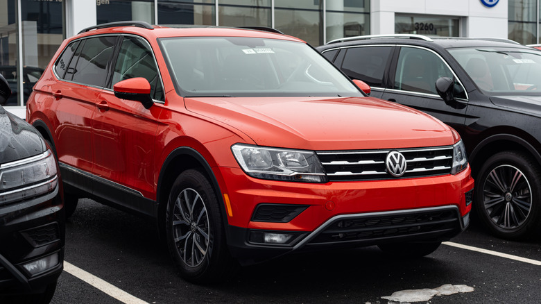 A red Volkswagen Tiguan parked at a dealership.