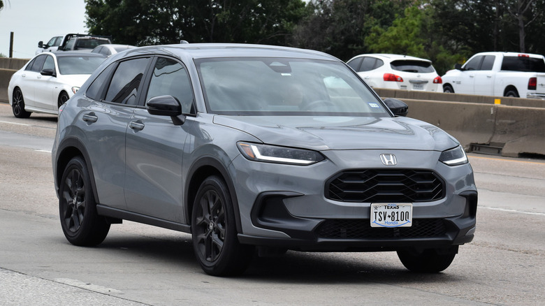 A portrait of a gray Honda HR-V SUV traveling down a highway in moderate traffic