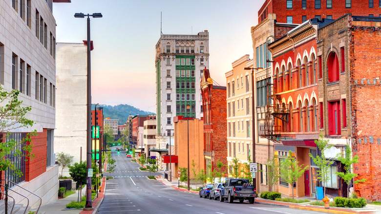A strip of older buildings in downtown Wheeling, West Virginia, with mountains in the background