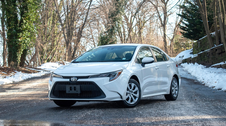 Toyota corolla in the winter time with snow, white car.