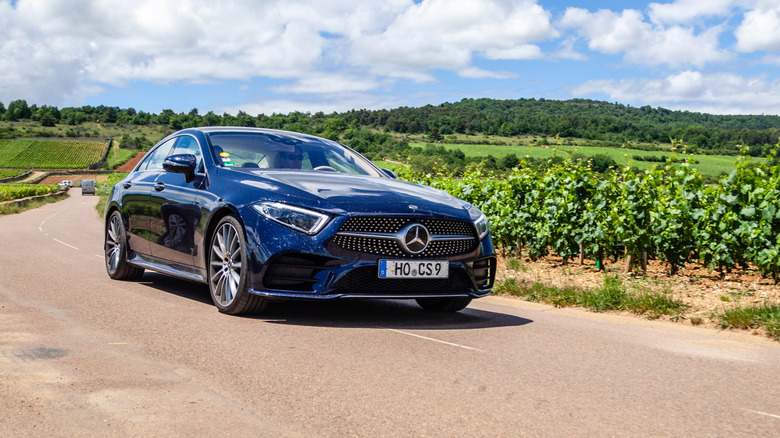 A Mercedes-Benz CLA driving on a stretch of road.