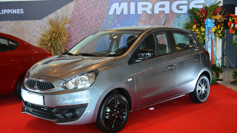 A Mitsubishi Mirage G4 on a red carpet in a showroom.