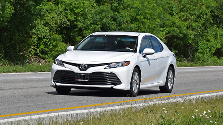 White Toyota Camry driving on the road.