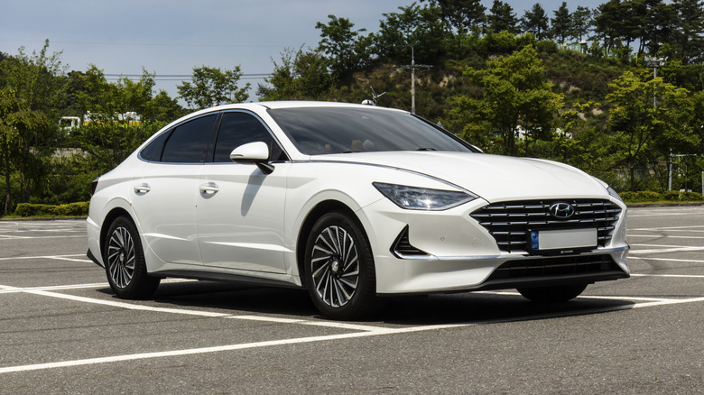 White Hyundai Sonata Hybrid car parked in an outdoor parking lot