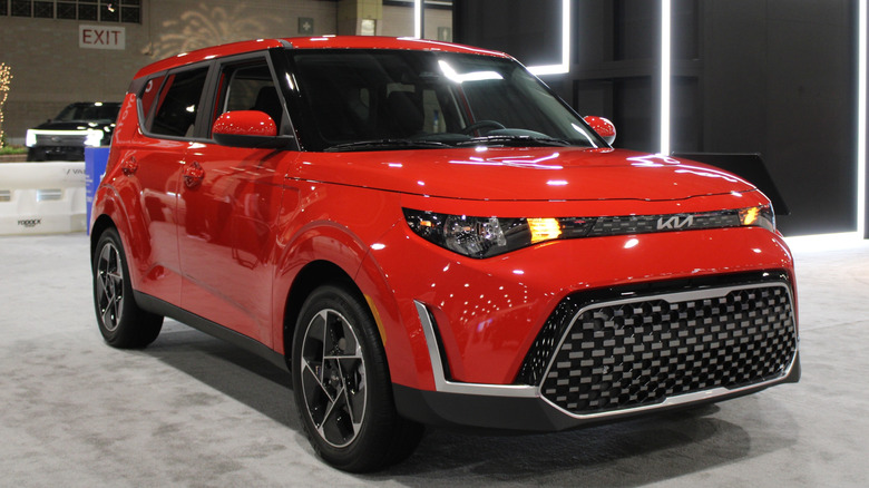 A red Kia Soul on display at an auto show.