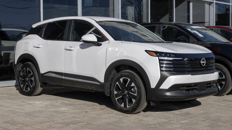 A white Nissan Kicks SL AWD on display at a dealership.
