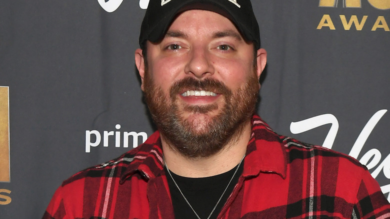 Chris Young smiling in front of black back drop