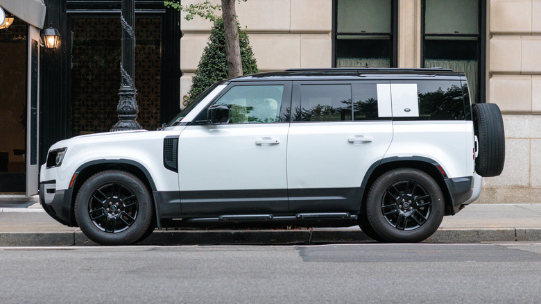 White Land Rover Defender parked on the street.
