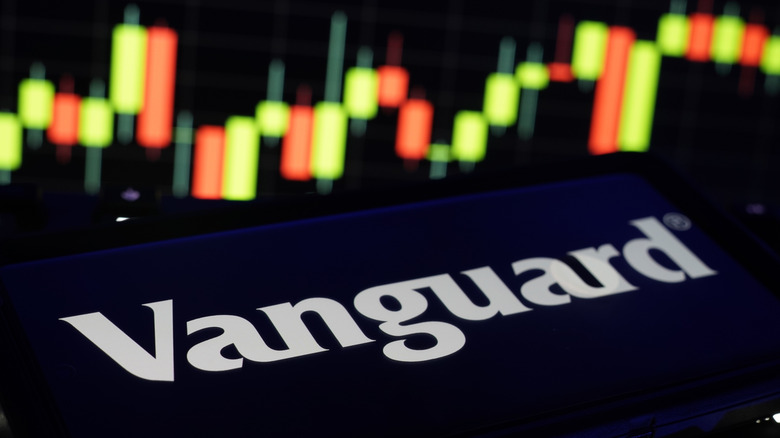 Vanguard Investment Management logo on mobile and computer screens with stock chart background.