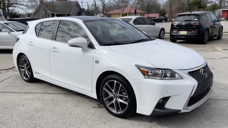 A white 2015 Lexus CT 200h hybrid car parked outsice of a dealership