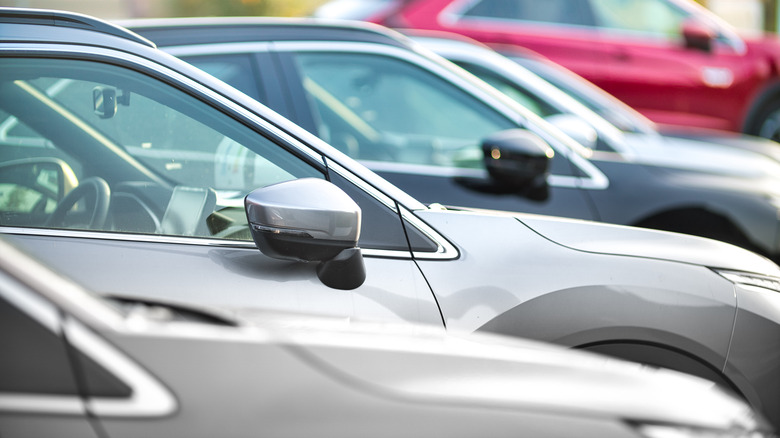 Side shot of a range of used modern vehicles, at a public car dealership