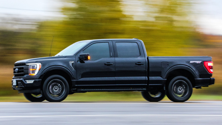 A black Ford F150 on a road against blur background