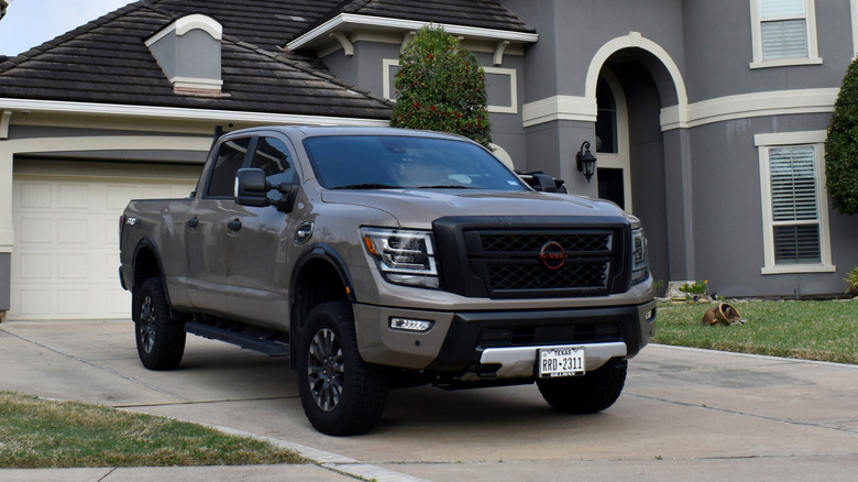 A portrait of a Nissan Titan XD pick-up truck in a driveway