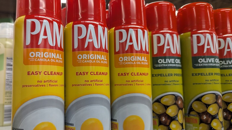Cannisters of PAM oil spray in original and olive oil flavor sitting on store shelf