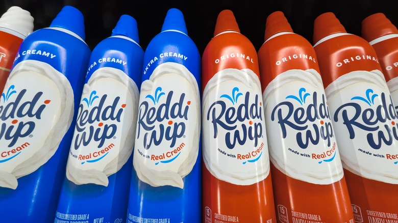 Close up of blue and white cannisters of Reddi-wip cream on a store shelf