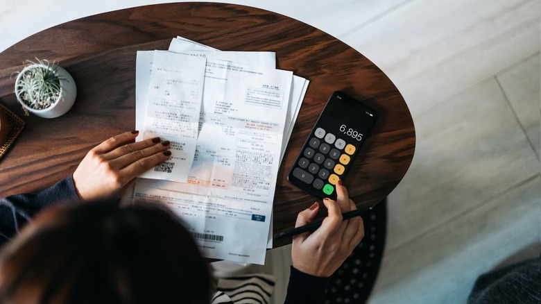 Overhead view of young woman managing personal banking and finance at home.