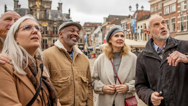A group of middle-aged adults travling through a European city.