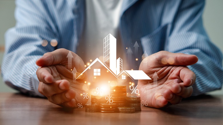 hands around a house image and money that's lit up