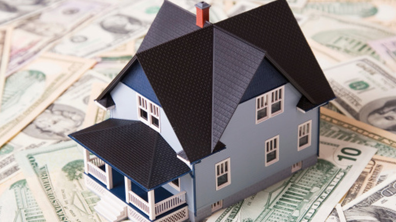 Small house on top of bills.