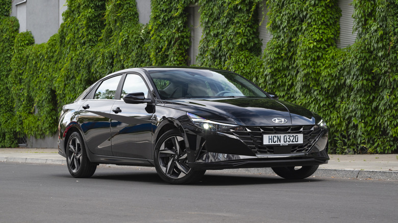 A black Hyundai Elantra VII stopped on a street.
