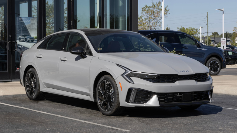 A Kia K5 GT-Line Sedan display at a dealership.
