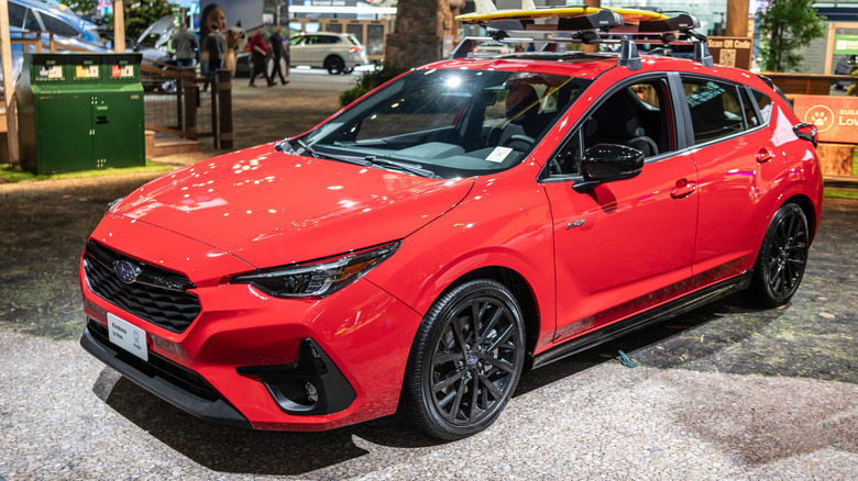 A red Subaru Impreza on display at an automotive show.