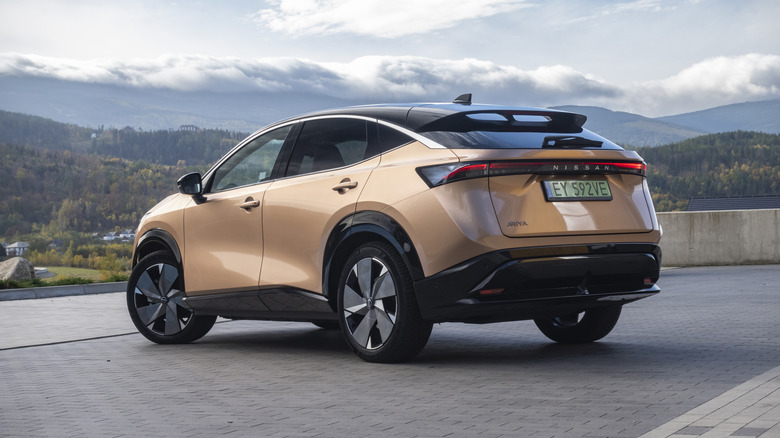 A copper Nissan ARIYA parked on a street.