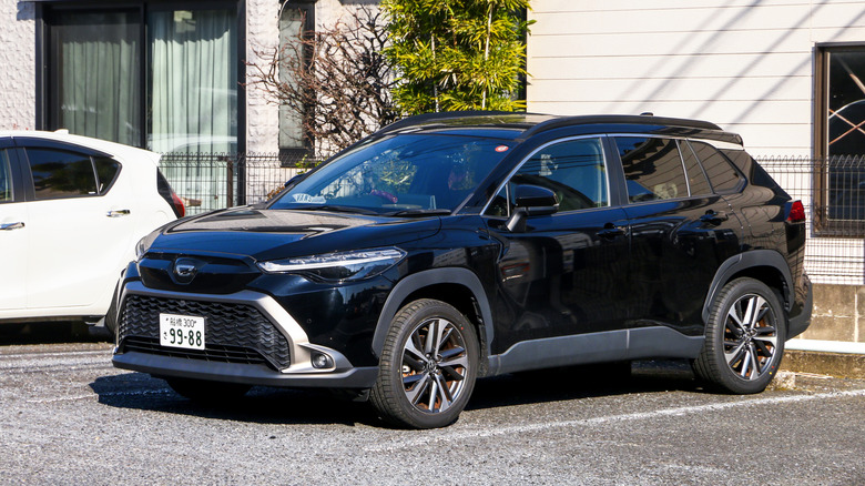 A  black Toyota Corolla Cross in the city street.